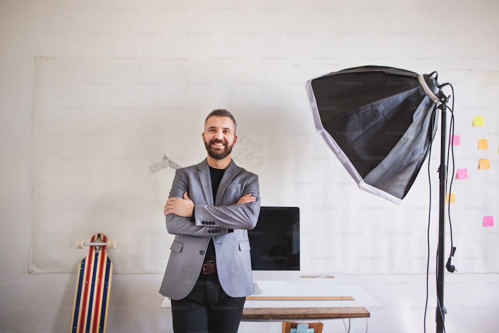 Portrait of a businessman standing at the desk in his office.