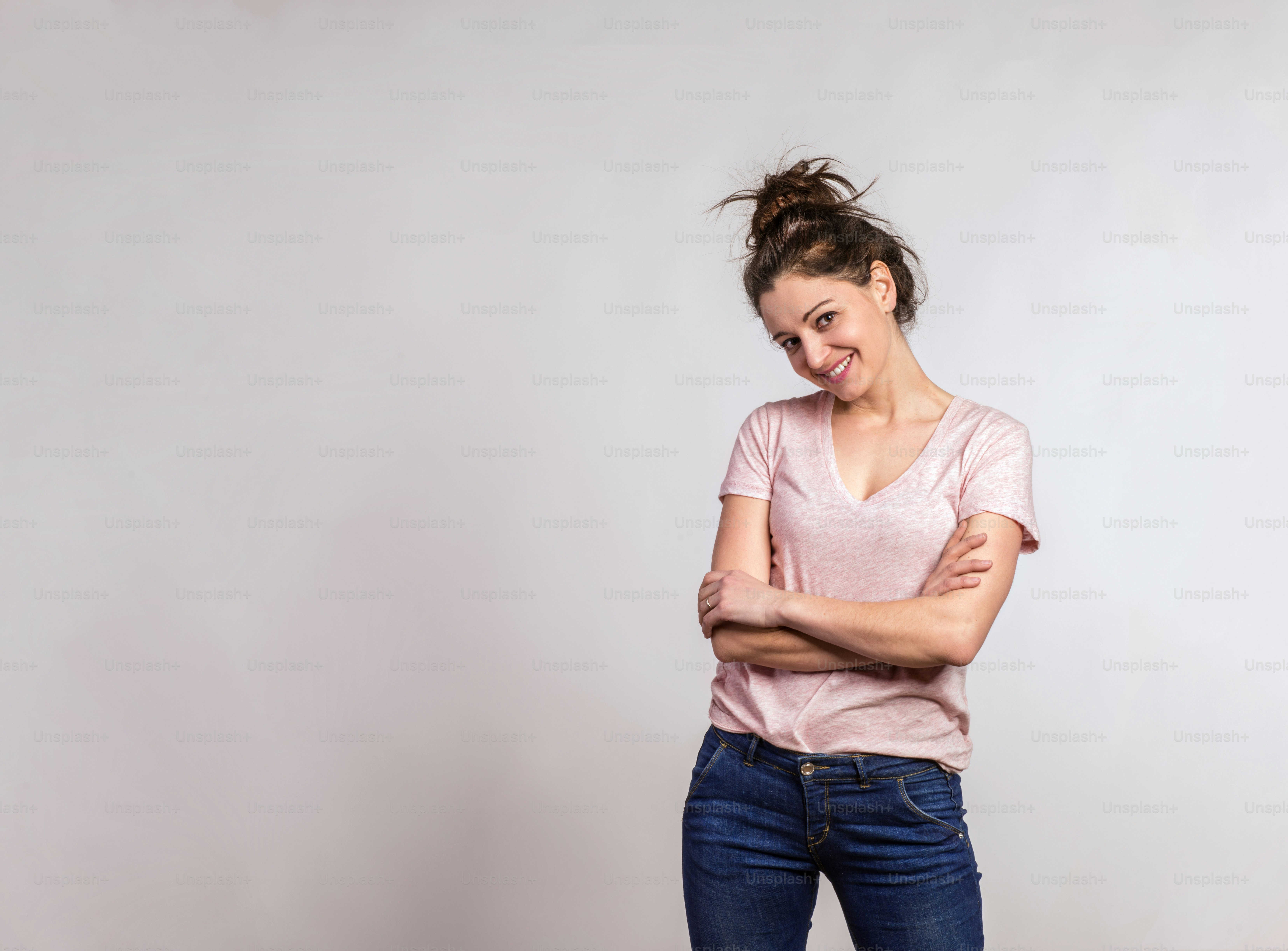 Portrait d’une belle jeune femme en atelier, les bras croisés.