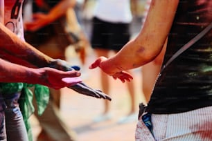Mains de hipsters heureux avec de la poudre colorée à Holi Fest, festival des couleurs en été