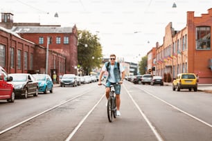 Handsome hipster enjoying city ride by bicycle