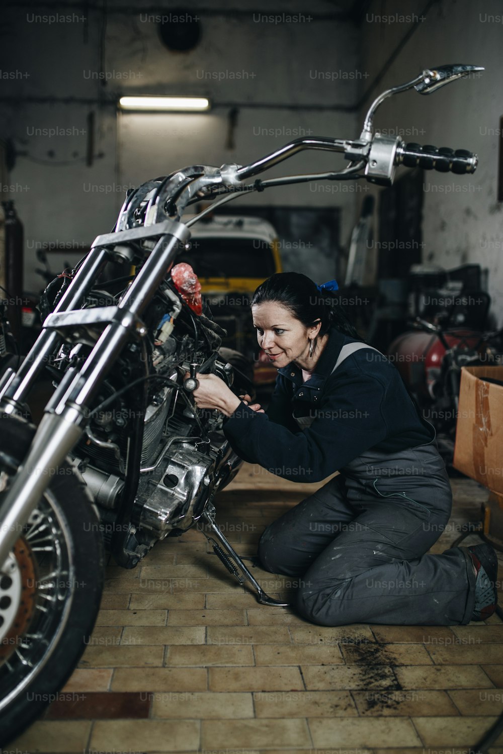車やバイクの修理工場で一生懸命働いている若い男。