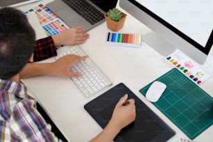 デザインスタジオのオフィスでデジタルタブレットで作業する魅力的なデザイナーチーム。