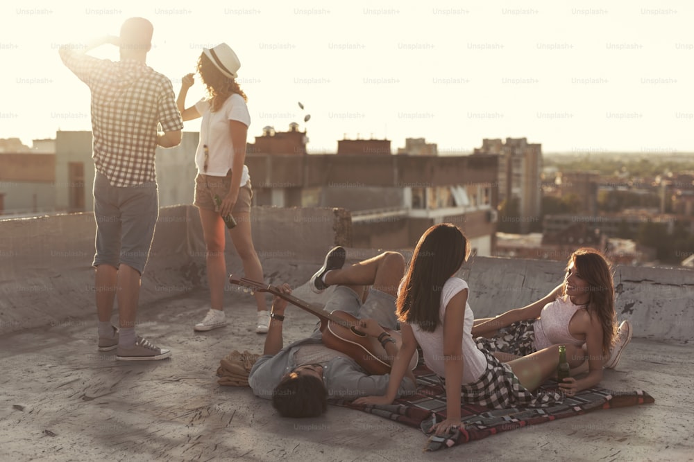 Young people chilling out and partying at a building rooftop