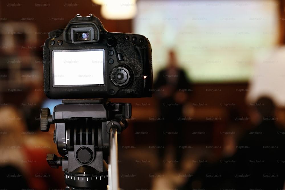 Foto-Videokamera mit leerem weißen Bildschirm bei der Aufzeichnung oder dem Fotografieren eines Meetings, Business Marketing Vortrag