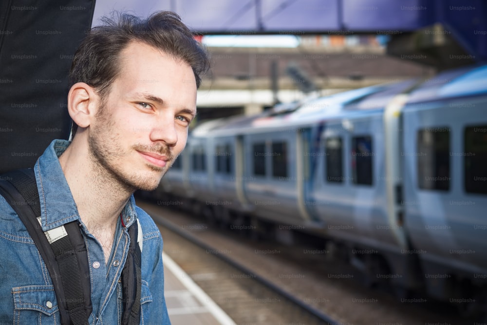 Portrait of a young man waiting for train on platform