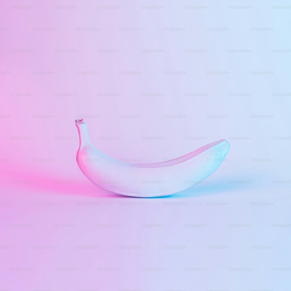 Banane in kräftigen holografischen Neonfarben mit kräftigem Farbverlauf. Konzeptkunst. Minimaler surrealistischer Hintergrund.