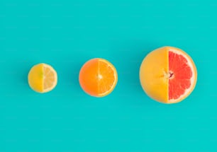 Lemon, orange and red grapefruit on bright blue background. Minimal flat lay concept.