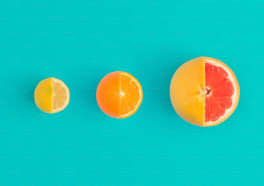 Zitrone, Orange und rote Grapefruit auf leuchtend blauem Hintergrund. Minimales Flachlegekonzept.