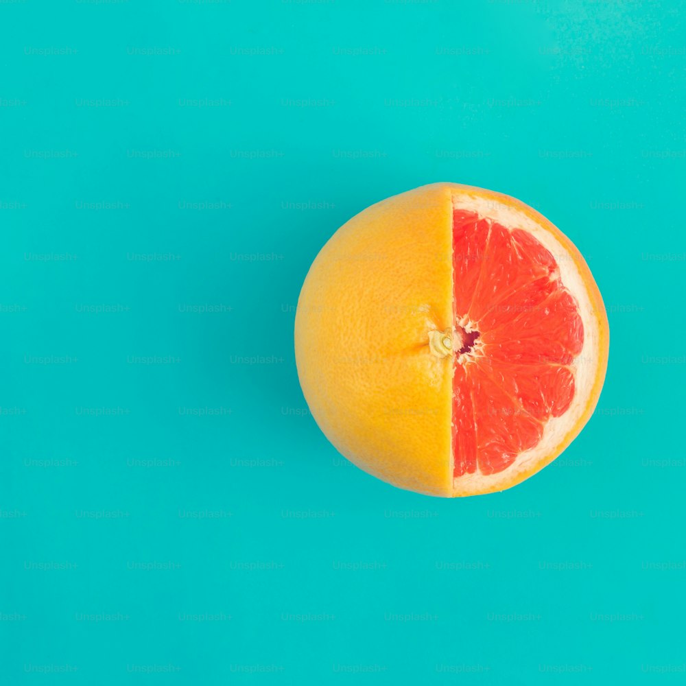 Red grapefruit on bright blue background. Minimal flat lay concept.