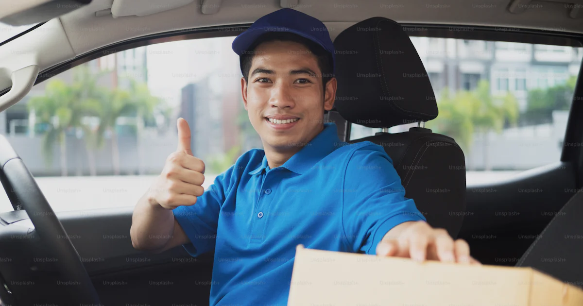 Drop Off Delivery Driver Delivery driver driving car with packages on seat outside the warehouse ...