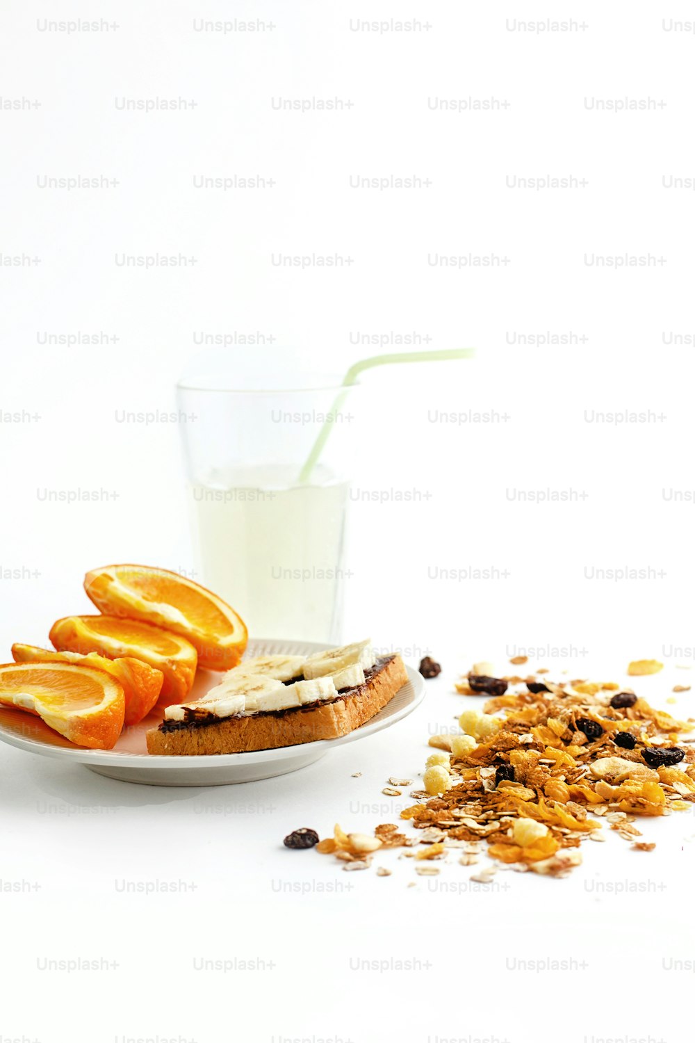 Délicieuses oranges juteuses et banane sur pain avec chocolat et boisson fraîche et granola sur fond blanc, concept d’alimentation saine