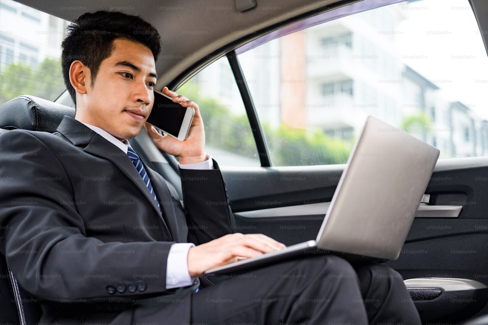 Businessman using computer working in the car.