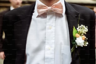 luxury stylish groom with boutonniere on elegant suit and bow tie close-up at wedding ceremony