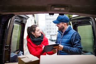 Young woman receiving parcel from delivery man - courier service concept.