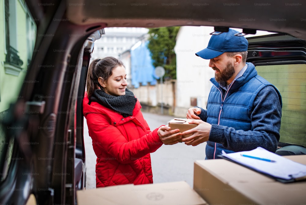 Young woman receiving parcel from delivery man - courier service concept.