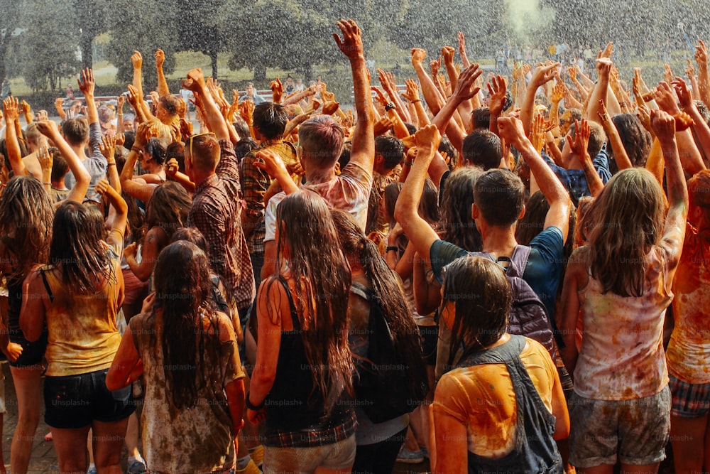 hands and happy people crowd partying under rain