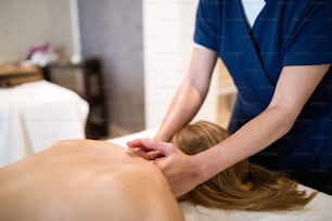 Masseur treating patient with therapeutic massage treatment
