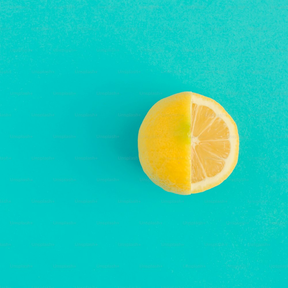 Gelbe Zitronenfrucht auf leuchtend blauem Hintergrund. Minimales Flachlegekonzept.