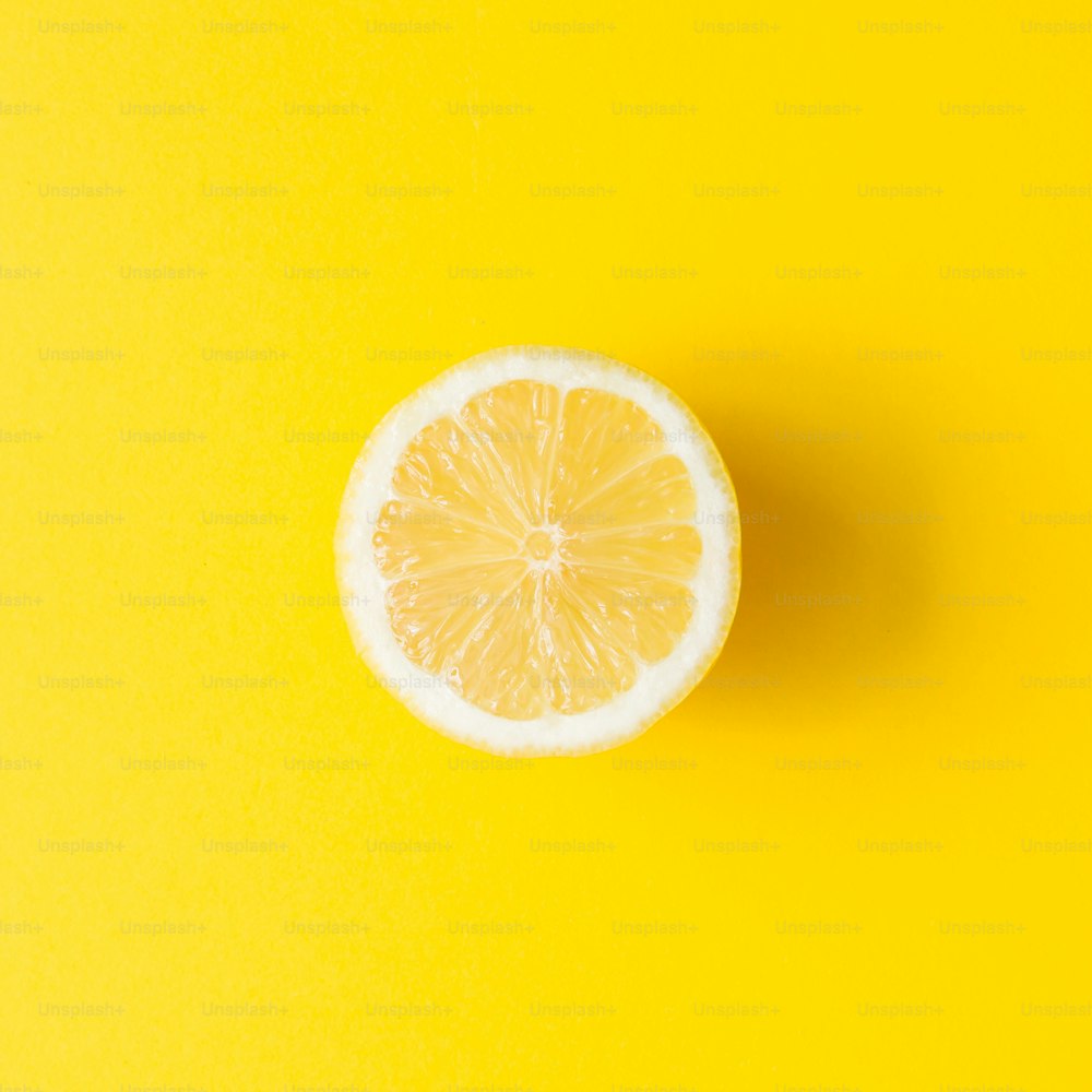 Zitrone auf leuchtend gelbem Hintergrund. Minimales Sommerkonzept. Flache Liege.