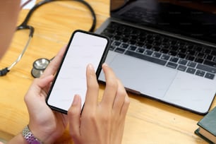 Cropped shot of hands of a doctor holding and touching screen of mobile phone