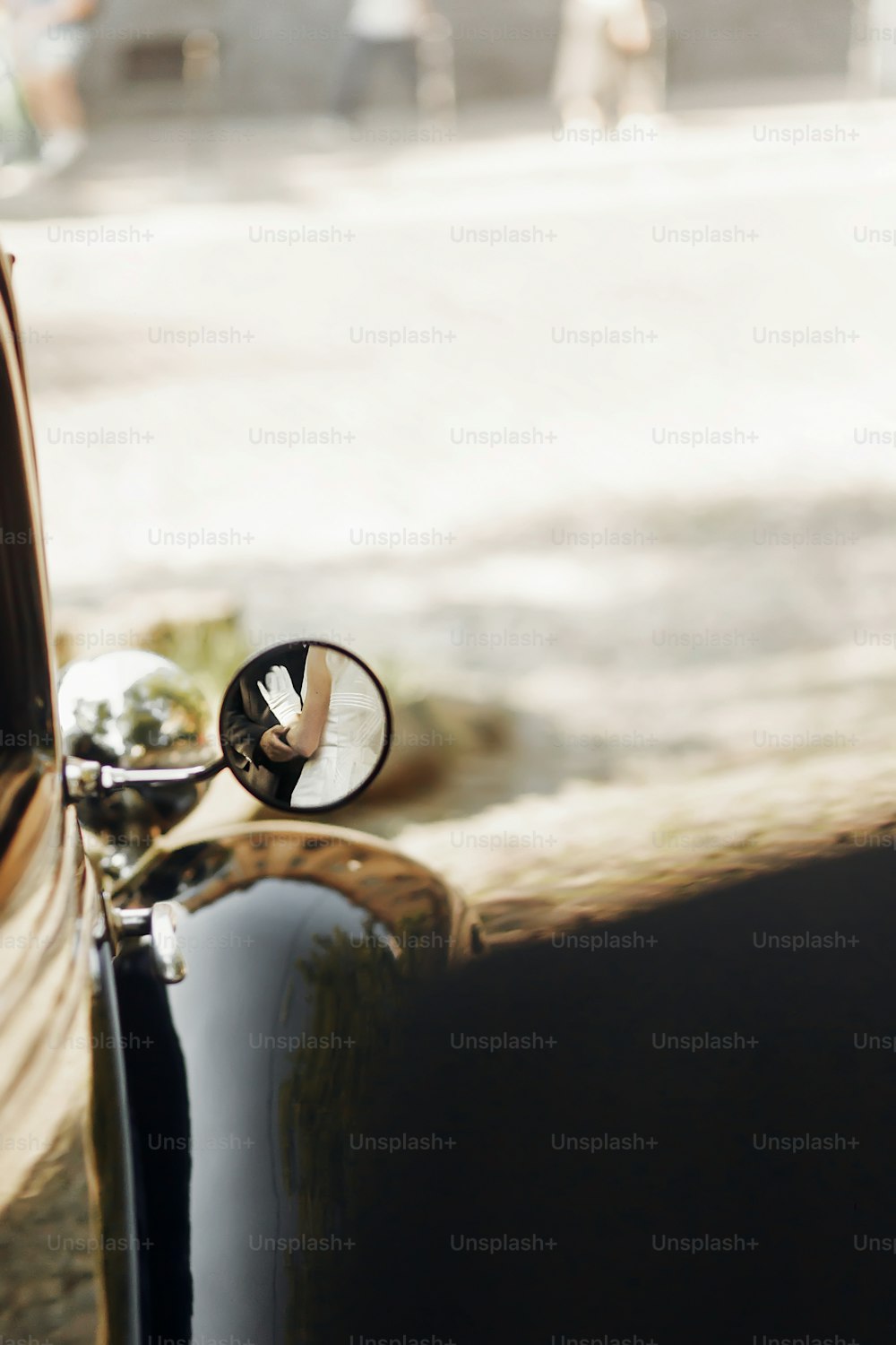 unusual view on luxury elegant wedding couple hugging, reflection in mirror of hands at stylish black car. retro style. romantic moment