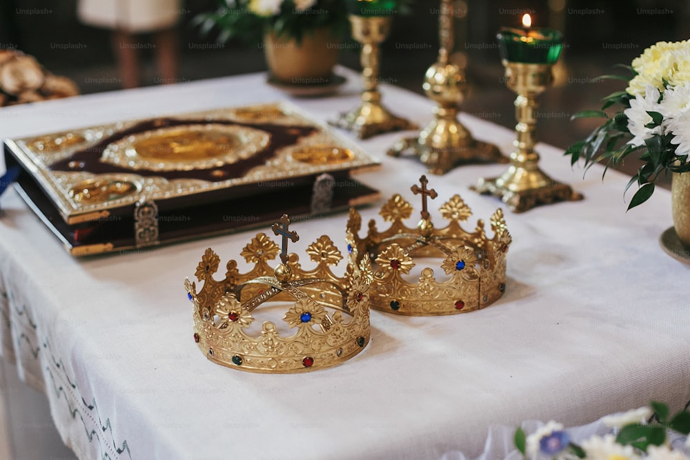 golden crowns and bible on holy altar during wedding ceremony in church. spiritual moments of holy matrimony
