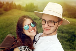 stylish hipster couple traveling and smiling on top of mountains in summer, travel together concept, space for text