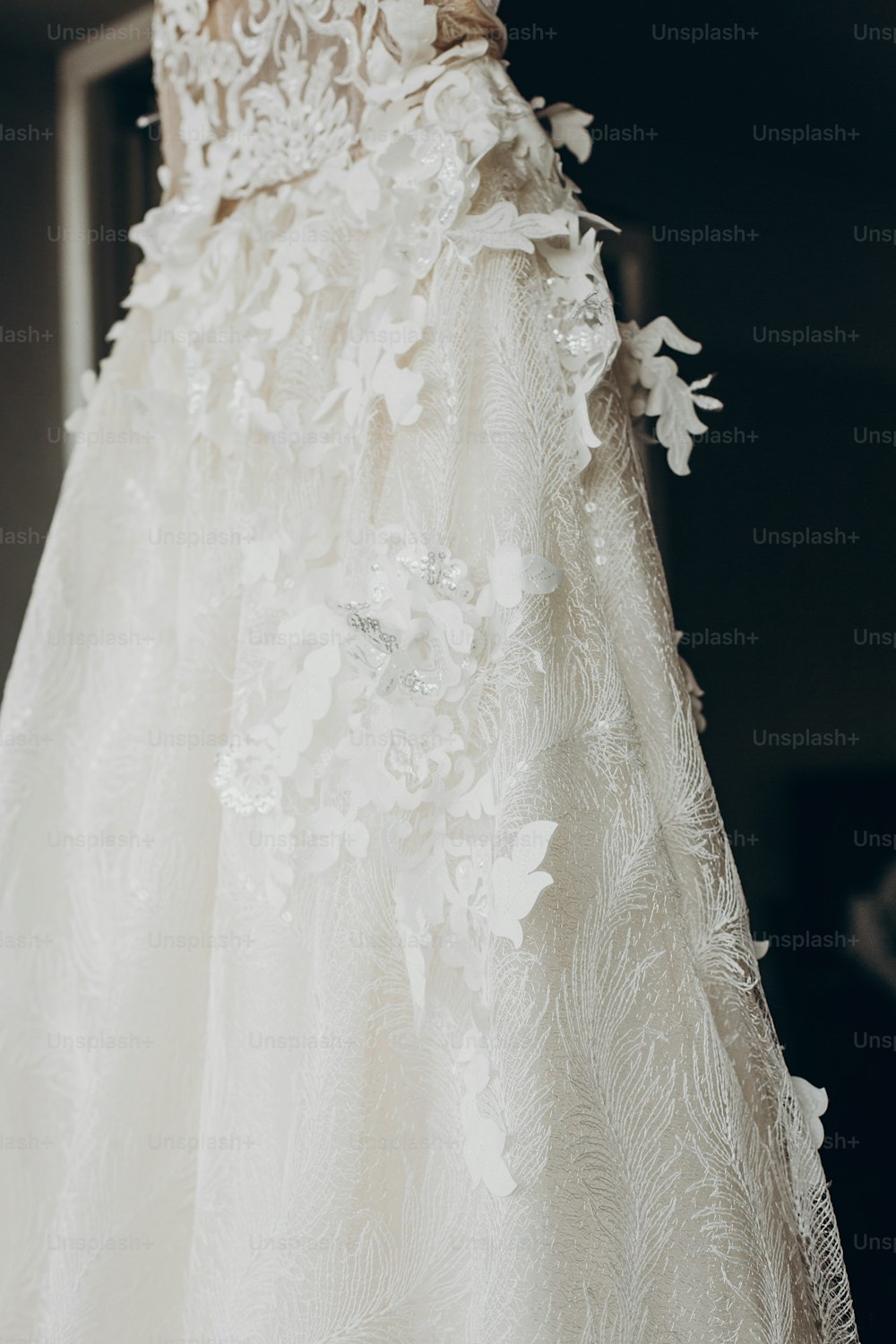 Luxus-Brautkleid-Detail, hängt am Fenster in einem Hotelzimmer. Modernes erstaunliches Brautkleid mit Blumen Nahaufnahme im Licht. Morgenvorbereitung, Vorbereitung vorbereiten. Platz für Text . Hochzeitstag