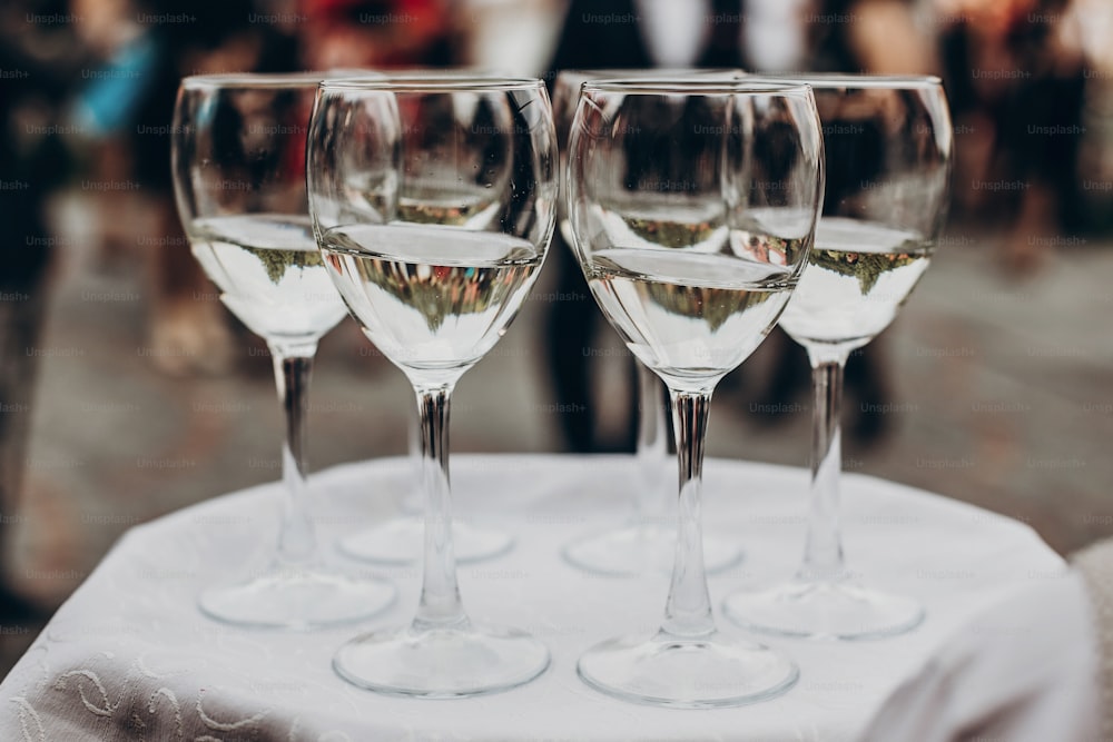 champagne and wine glasses on tray at luxury wedding reception at restaurant.  waiter serving drinks among guests at stylish celebration. luxury life concept. space for text