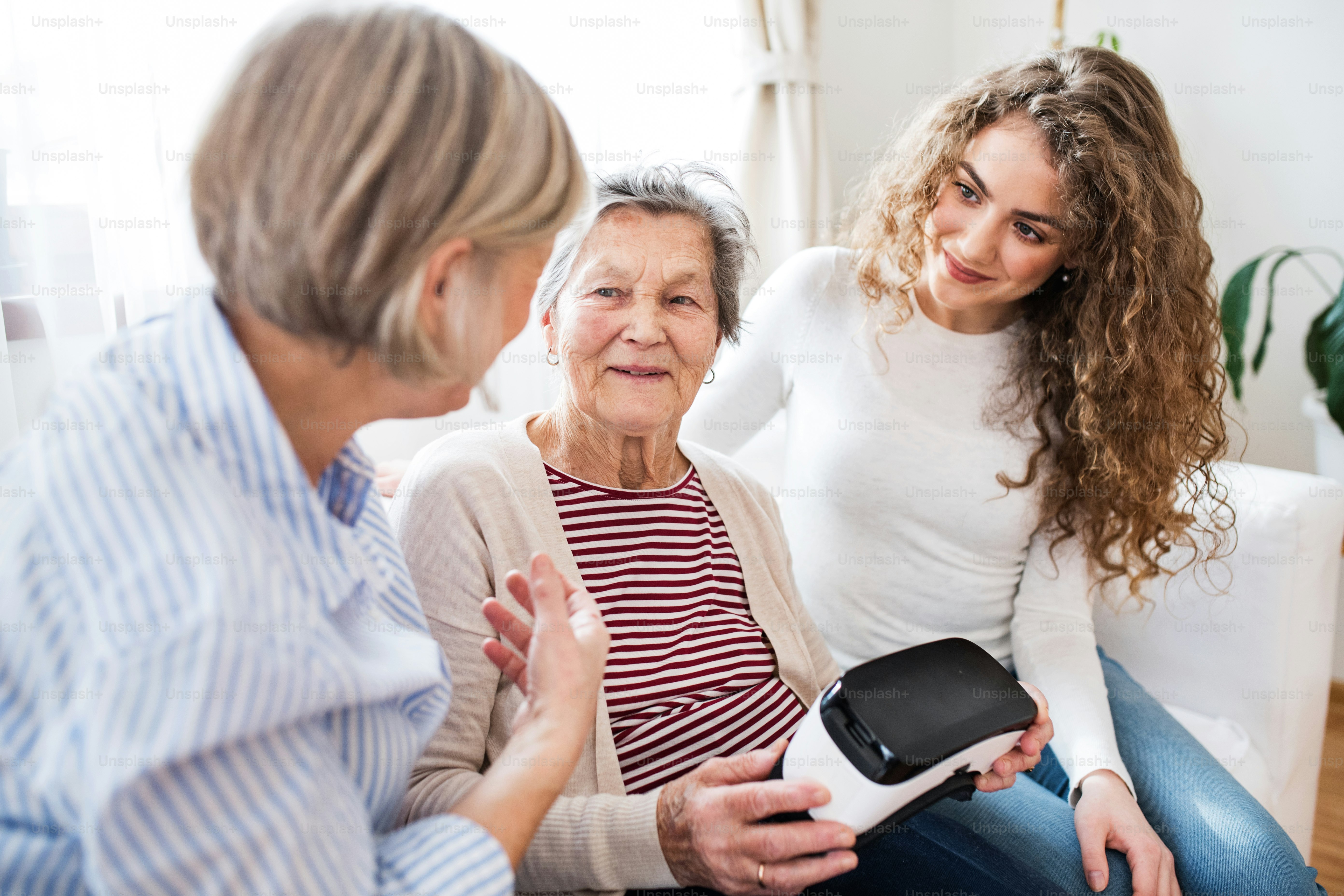 10代の少女と、自宅でVRゴーグルを装着した母親と祖母。家族と世代の概念。