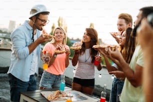 Group of happy young friends having party on rooftop