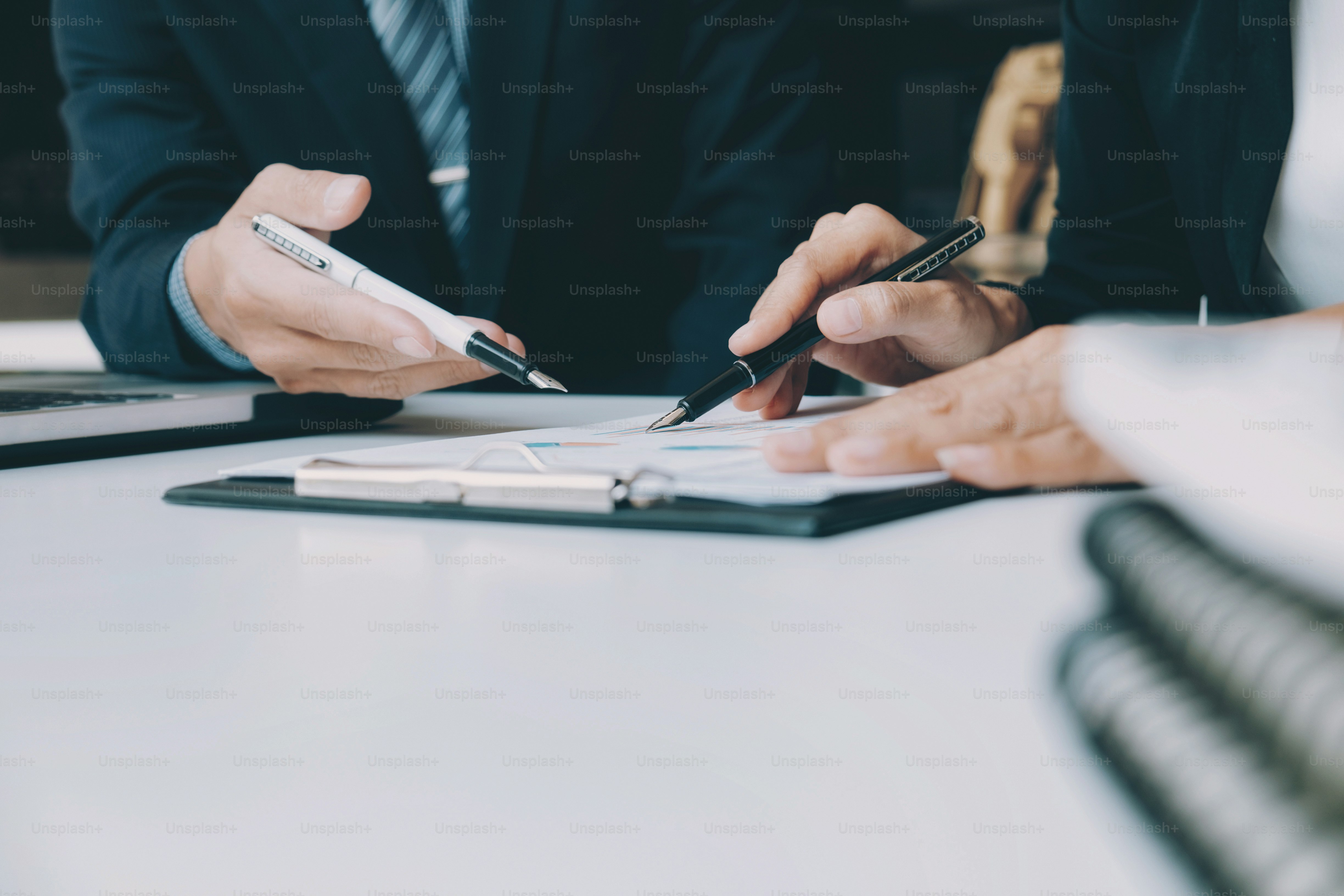 Tim bisnis bekerja proses pertemuan brainstroming. Pebisnis mendiskusikan bagan dan grafik yang menunjukkan hasil kerja tim mereka yang sukses.