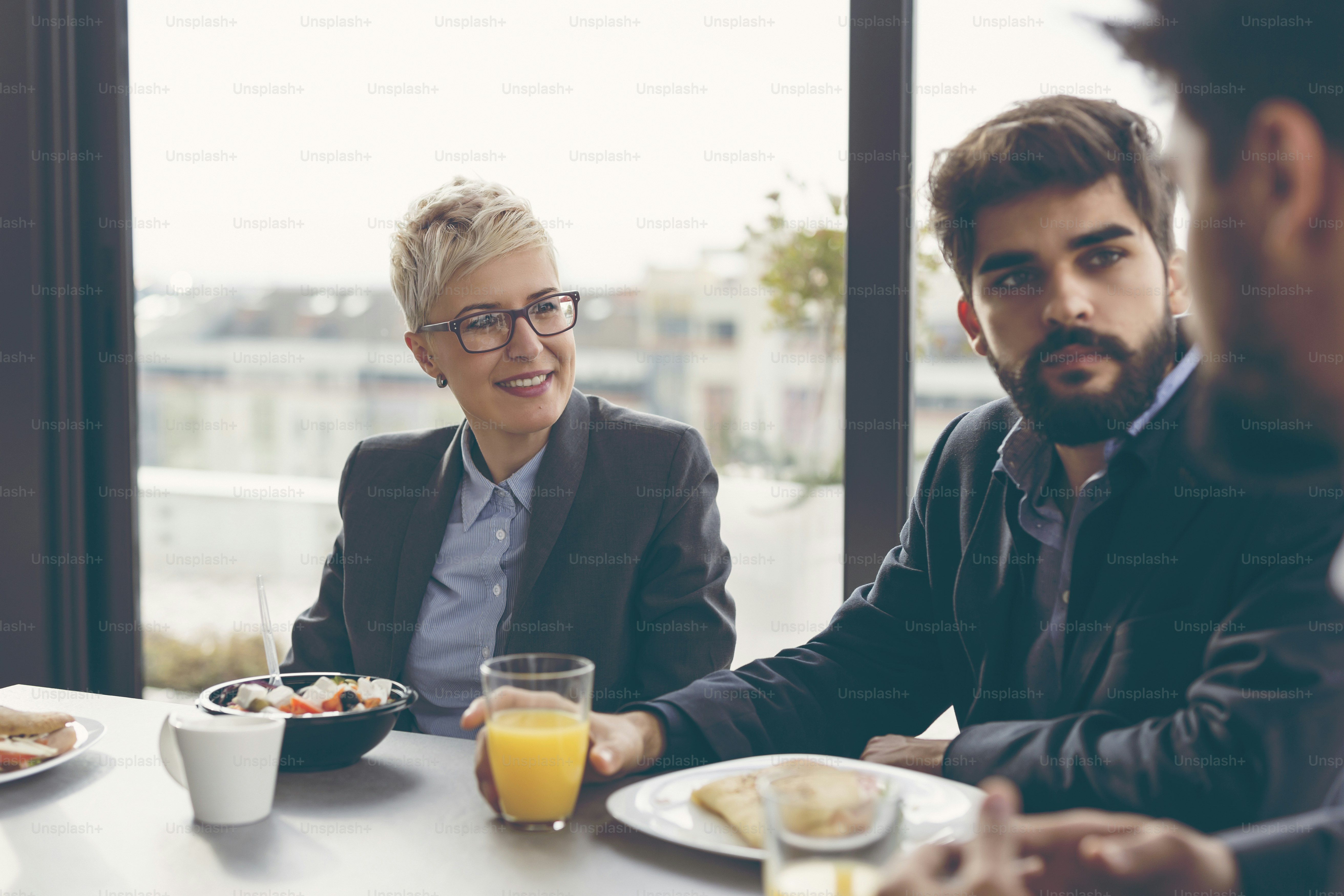 Group of business people having breakfast in company's restaurant. Focus on the woman