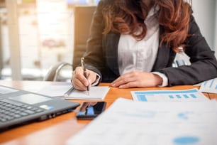 Business woman at working with financial reports and laptop computer in the office