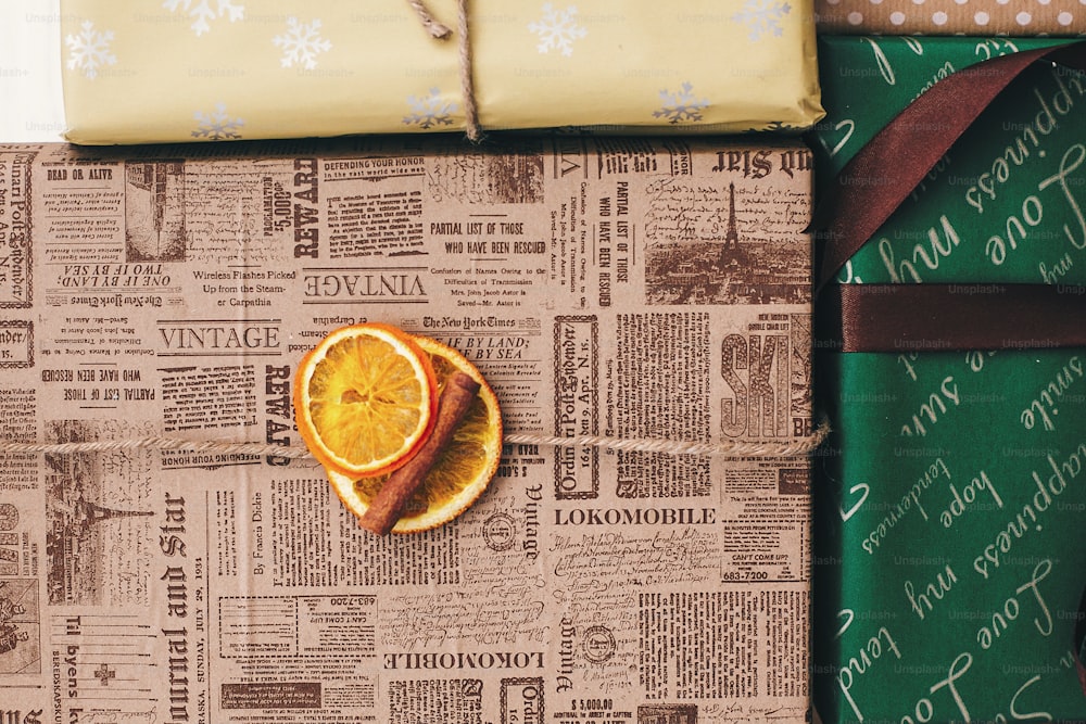 Elegantes cajas de regalo envueltas en la vista superior, con adornos de canela naranja y cordel. Feliz Navidad y Feliz Año Nuevo concepto. Imagen plana. Saludos de temporada, felices fiestas