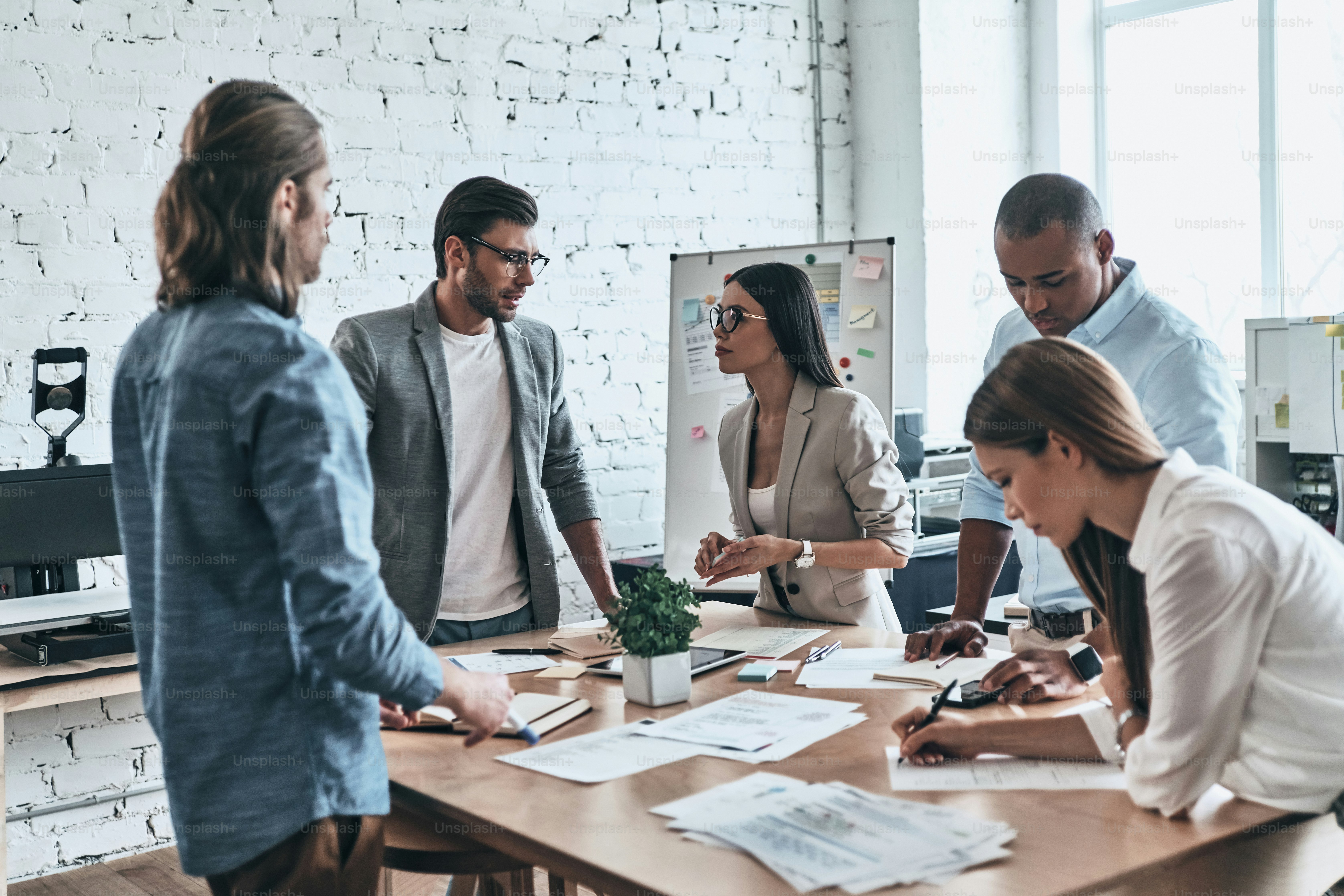 Group of young business people working and communicating while spending time in the office