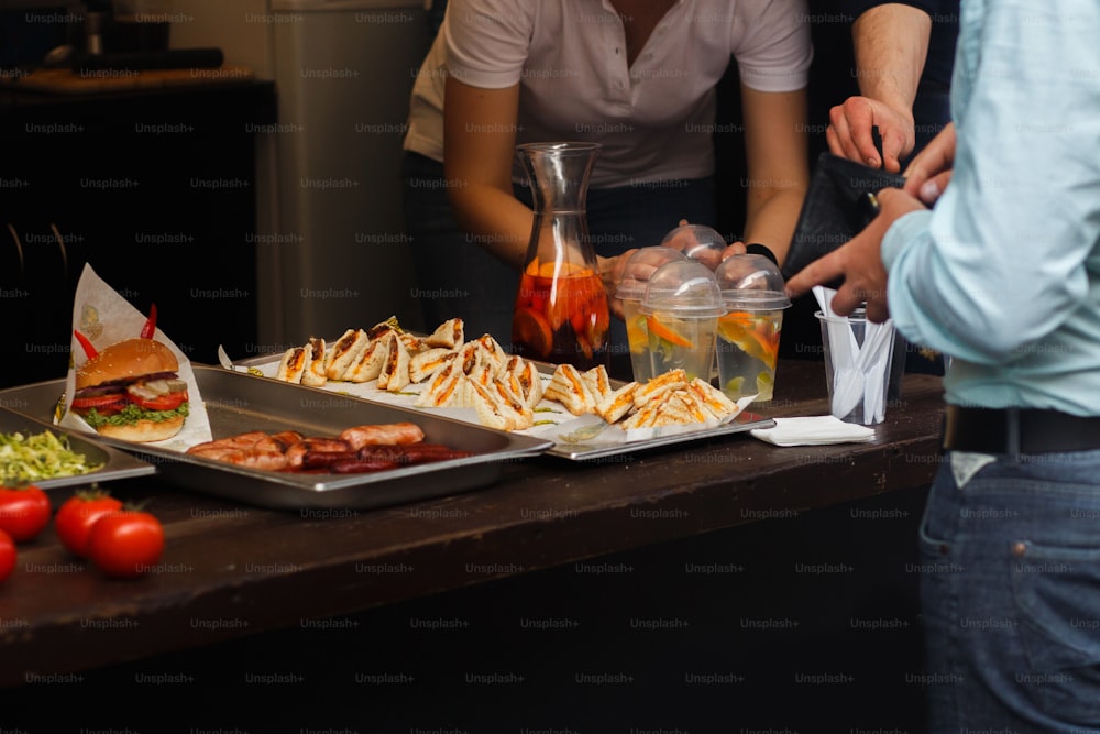 delicious burgers and bbq sandwiches, man buying at open grill, serving at outdoor kitchen. food festival in city. tasty food roasting, food-court. summer picnic