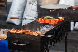 delicioso churrasco kebab legumes grelhando na grelha aberta, cozinha ao ar livre. festival gastronômico na cidade. saborosa assada de alimentos, praça de alimentação. piquenique de verão