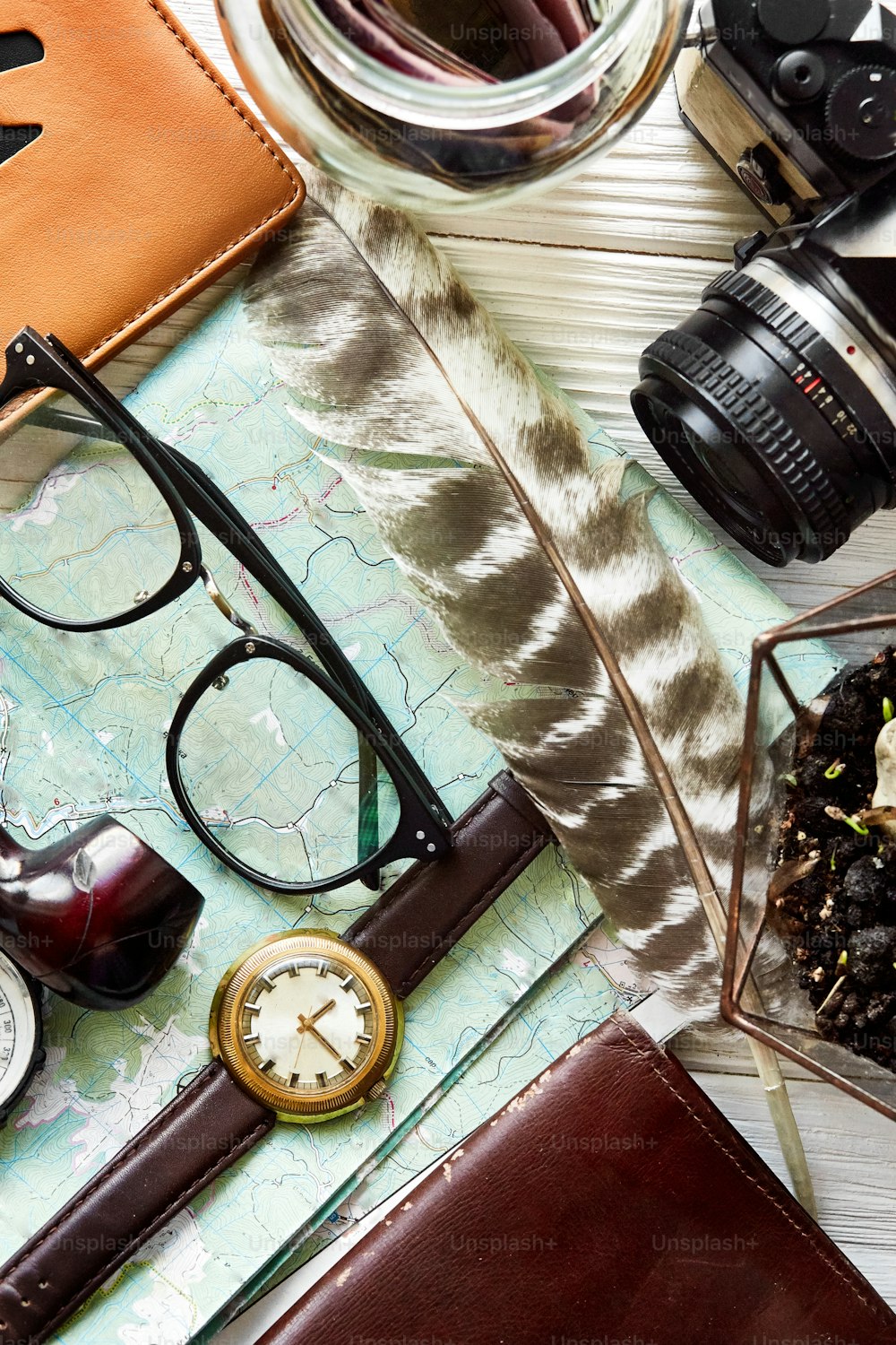 여행 시간 개념, 힙스터 플랫 레이. 지도 여권 돈 나침반과 안경 파이프 카메라 깃털은 흰색 나무 배경 평면도에 있습니다. 휴가 계획. 텍스트, 방랑벽 및 탐험을위한 공간