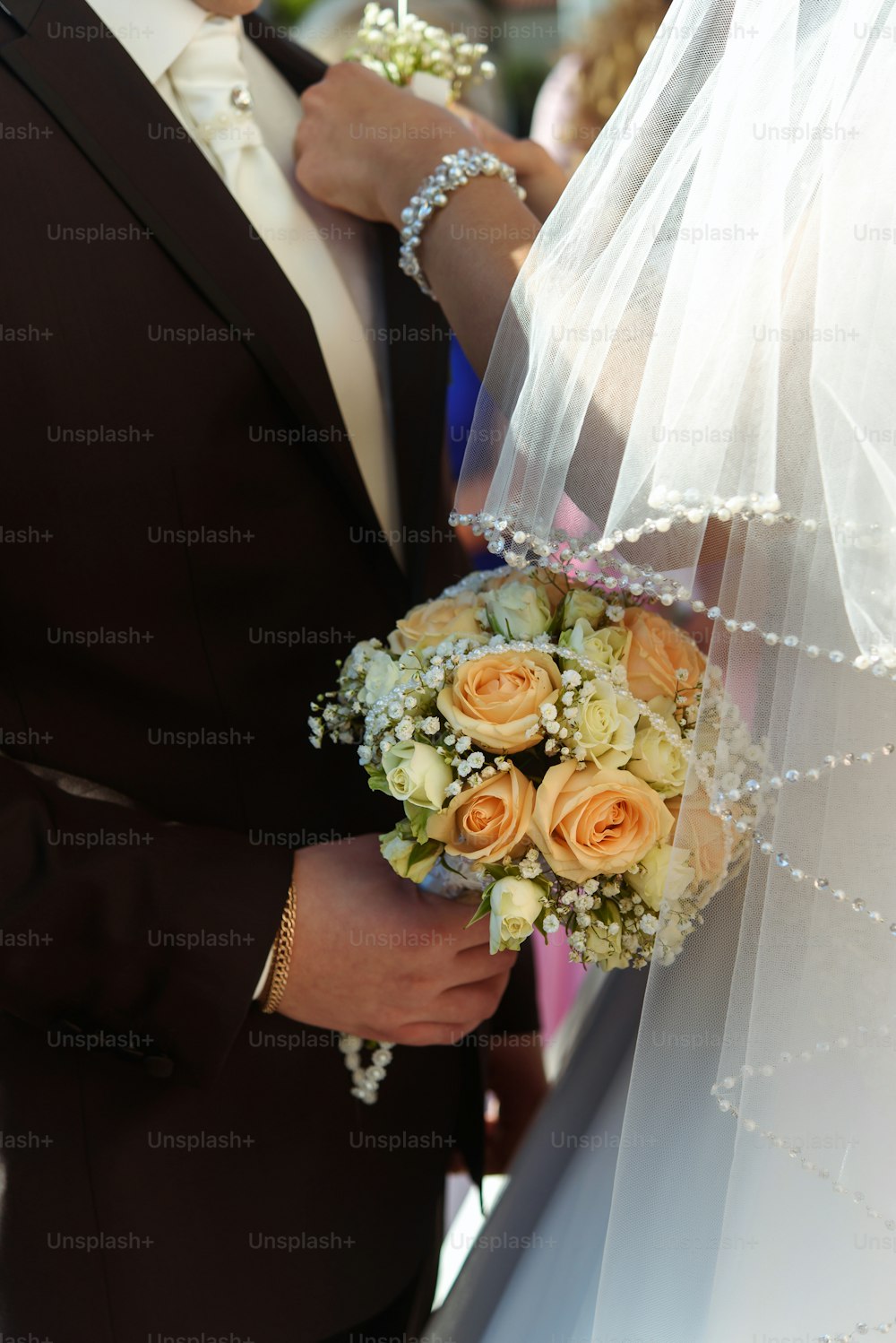 Luxusbraut zieht bei der Hochzeitszeremonie Boutonniere im Bräutigamanzug an