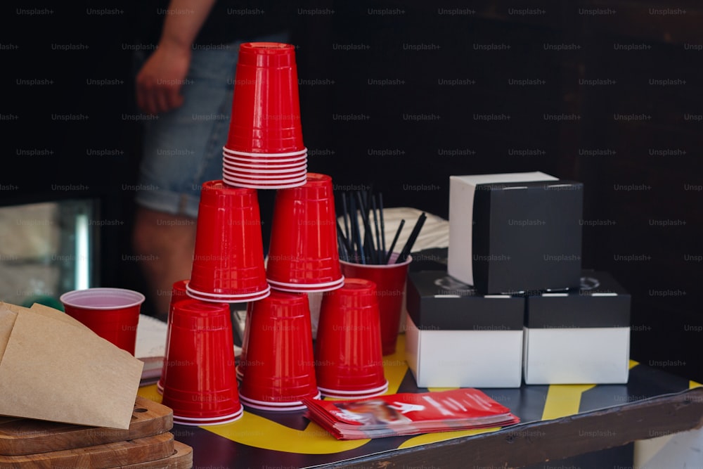 copos vermelhos vazios na mesa para cerveja ou bebidas no mercado, cozinha ao ar livre. festival gastronômico na cidade.  praça de alimentação. piquenique de verão