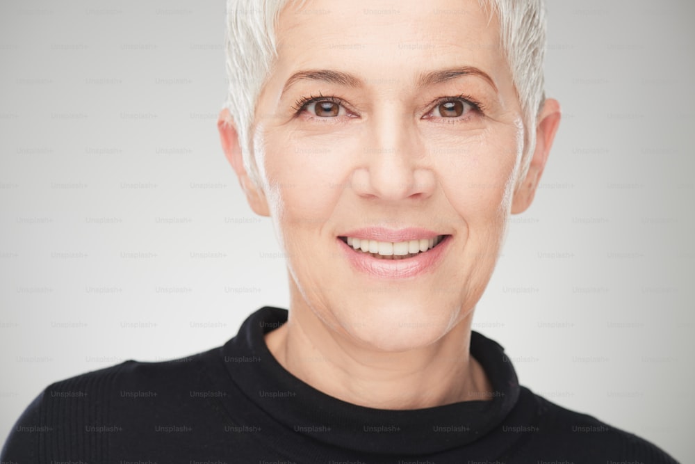 Portrait of beautiful senior woman in front of white background.