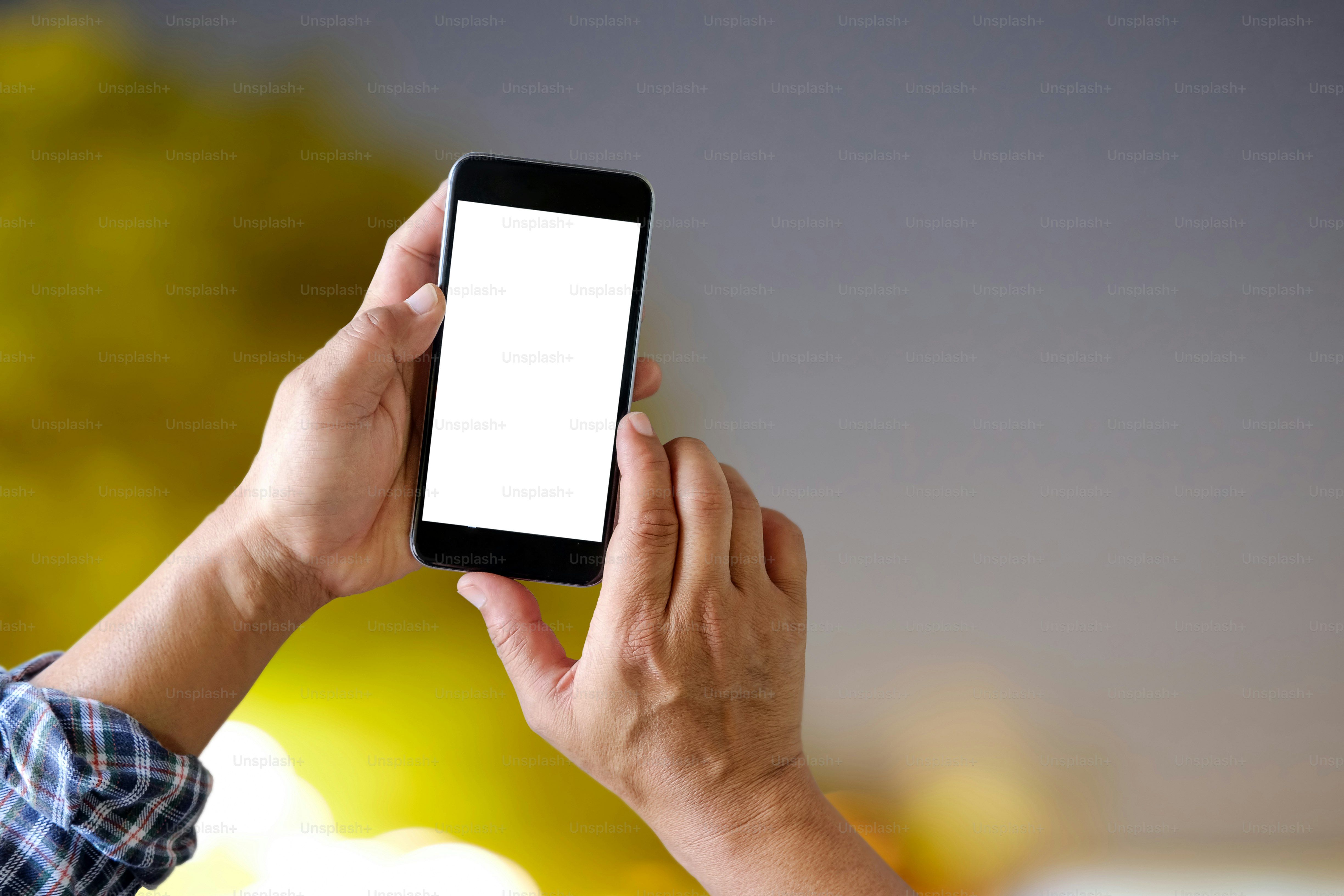 Gros plan sur la main masculine à l’aide d’un téléphone intelligent et d’un arrière-plan bokeh nocturne.