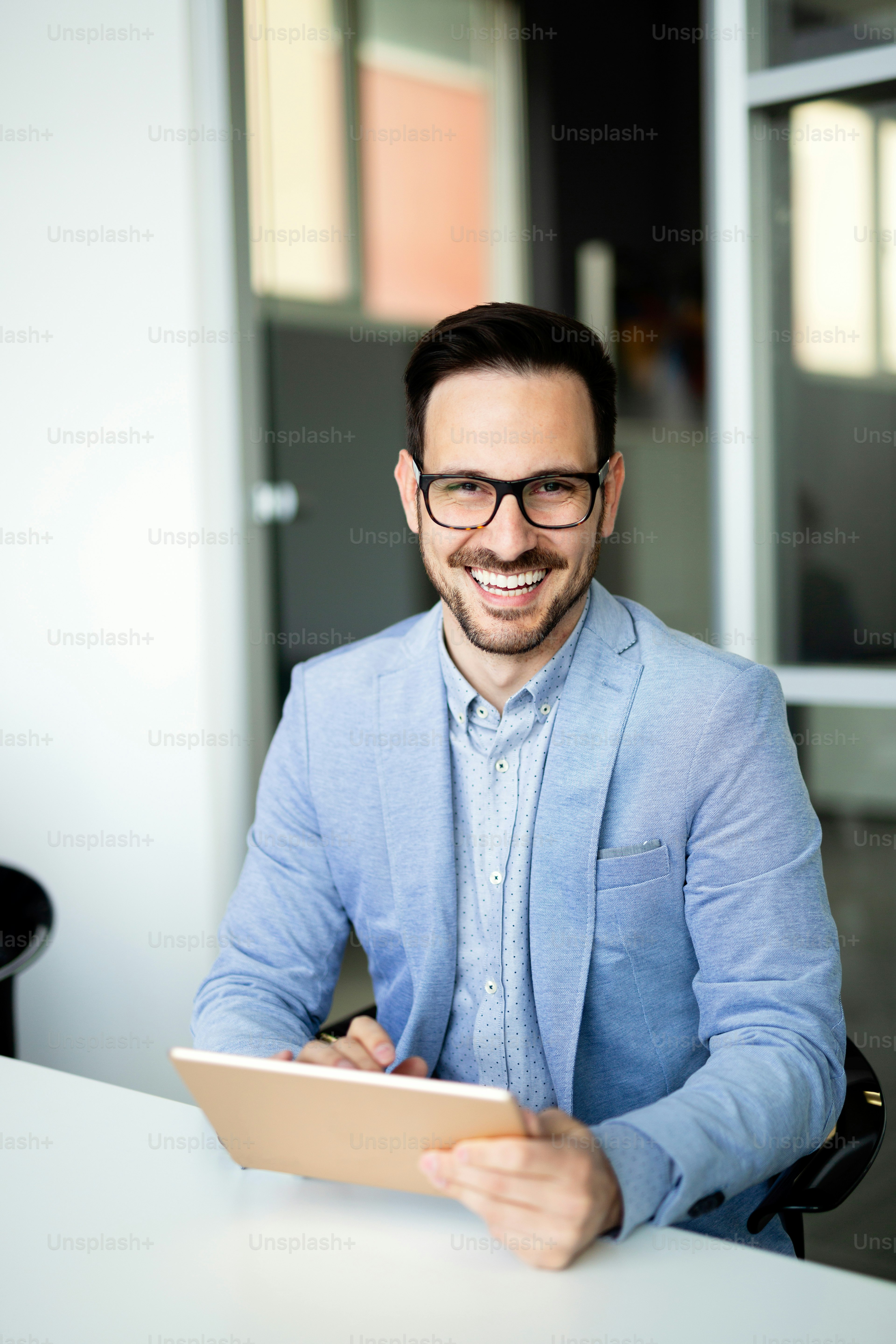 Portrait of handsome successful smiling businessman holding tablet