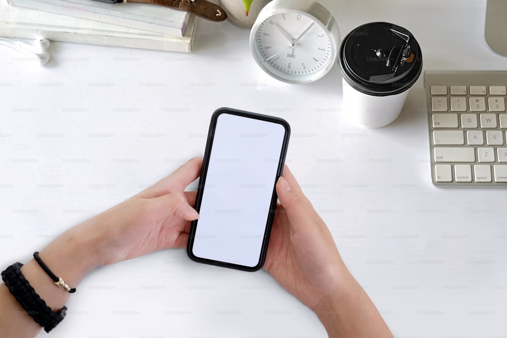 Attractive woman using smartphone over office desk workspace