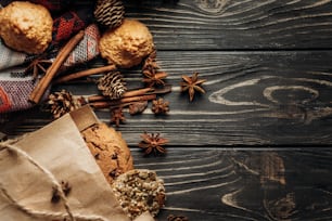 biscotti cupcakes e spezie su sfondo di legno, elegante rustico invernale flat lay. spazio per il testo. Atmosfera accogliente autunnale. concetto di panetteria per le vacanze stagionali