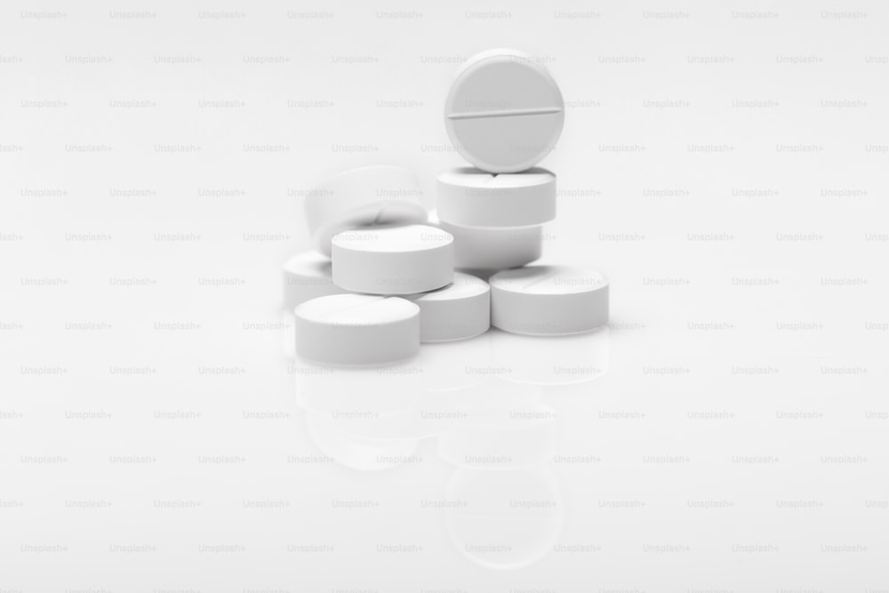 varie pillole bianche su sfondo bianco