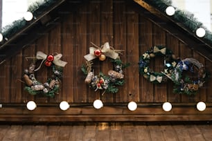 stylish luxury christmas garland lights and wreaths on wwooden cabins, celebration decoration for holidays in the city