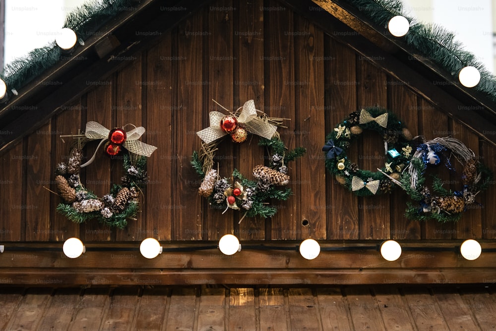 stylish luxury christmas garland lights and wreaths on wwooden cabins, celebration decoration for holidays in the city