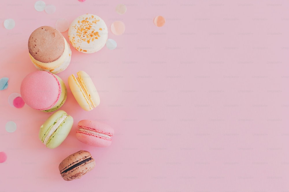 Modernes Food-Fotografie-Konzept. Stilvolle bunte Makronen auf trendigem rosa Papier, flach gelegt. Platz für text.leckere rosa, gelbe, grüne, weiße, braune Macarons. leckerer Hintergrund